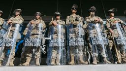 de la Guardia Nacional de California montan guardia frente al Edificio Federal antes de la entrada en vigor del toque de queda en Los Ángeles el 10 de junio de 2025, tras días de protestas en respuesta a las operaciones federales de inmigración que provocaron enfrentamientos en el centro de la ciudad.