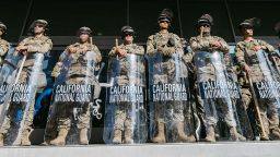 Members of the California National Guard stand guard outside the Federal Building before a curfew takes effect in Los Angeles on June 10, 2025, following days of protests in response to federal immigration operations that saw clashes spread across downtown. The overnight curfew followed days of unrest sparked by federal immigration operations, with Mayor Karen Bass stating the measure aimed to "stop the vandalism, to stop the looting" after prolonged protests. (Photo by David Pashaee / Middle East Images via AFP) (Photo by DAVID PASHAEE/Middle East Images/AFP via Getty Images)          