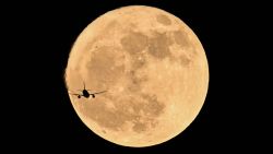 An aircraft es in front of the full moon, known as the 'Strawberry Moon' in Chongqing, southwest China on June 11, 2025. (Photo by Hector RETAMAL / AFP) (Photo by HECTOR RETAMAL/AFP via Getty Images)