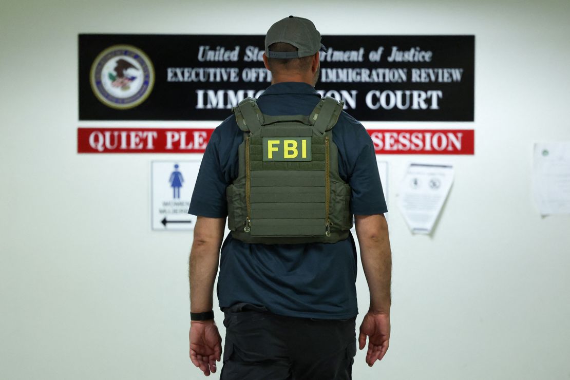 A member of the FBI waits in a hallway outside of a courtroom at New York-Federal Plaza Immigration Court inside the Jacob K. Javitz Federal Building in New York City on June 11.