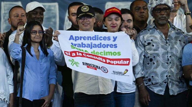 Colombia's President Gustavo Petro (C) holds a sign with a message in  of the referendum and social reforms proposed by the government next to the director of the istrative Department of the Presidency (DAPRE), Angie Rodriguez (L), during a rally at San Francisco Square in Cali, Colombia, on June 11, 2025. Colombia was rocked by a string of 24 coordinated bomb and gun attacks that killed at least seven people across the country's southwest on June 10, 2025, deepening a security crisis roiling the Andean nation. (Photo by JOAQUIN SARMIENTO / AFP) (Photo by JOAQUIN SARMIENTO/AFP via Getty Images)          