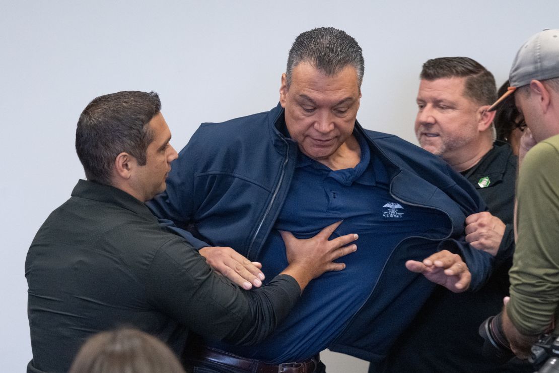 Sen. Alex Padilla is pushed out of the room as Homeland Security Secretary Kristi Noem holds a news conference in Los Angeles on Thursday, June 12, 2025.