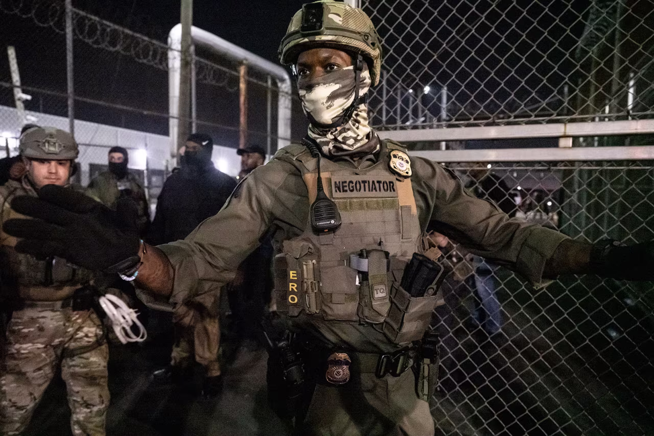 Immigration and Customs Enforcement (ICE) agents guard outside Delaney Hall, a migrant detention facility, while anti-ICE activists demonstrate on Thursday night in Newark, New Jersey.
