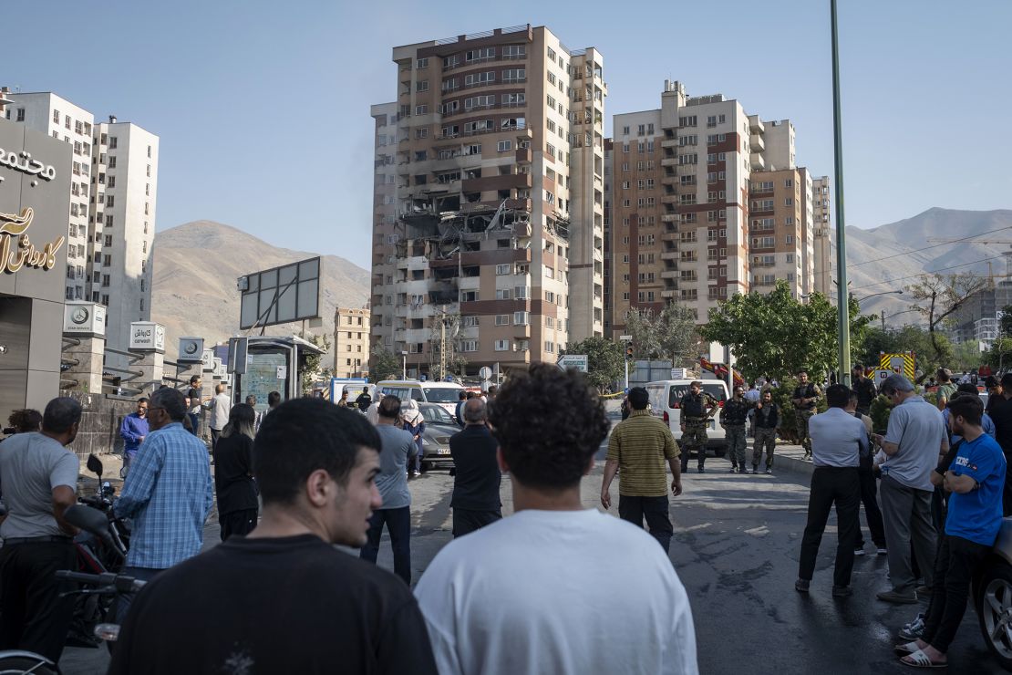 Iranian people gather at the scene of an explosion at a residential complex due to Israeli attacks in Tehran, Iran, on June 13.