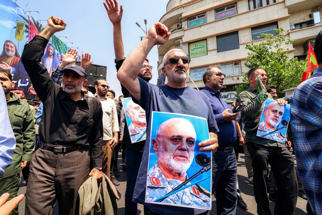 People hold pictures of Major general Gholam Ali Rashid, senior commander of Iran's Islamic Revolutionary Guard Corps (IRGC), as they gather for a protest against Israel's wave of strikes on Iran in Enghelab Square in central Tehran on Friday.