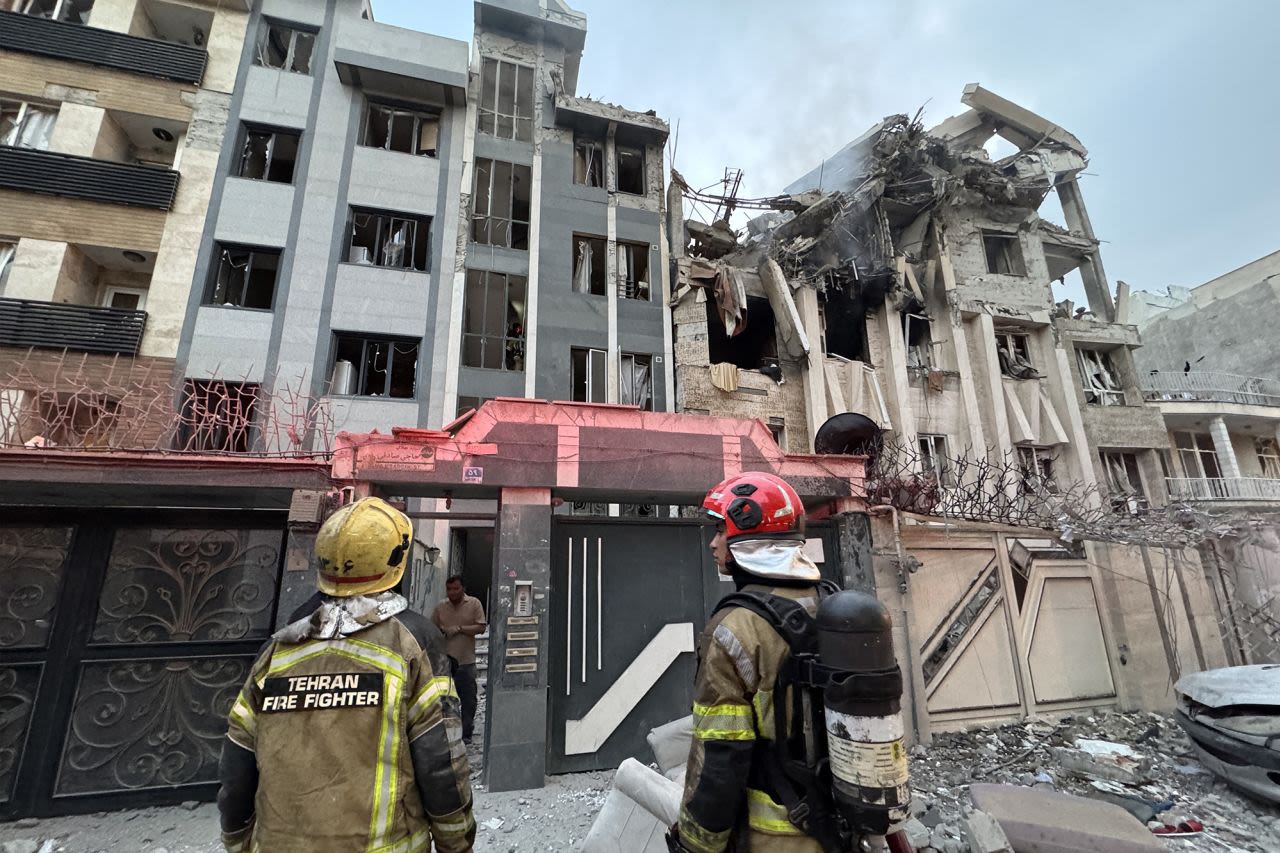 Equipos de emergencia se reúnen frente a un edificio alcanzado por un ataque israelí en Teherán este viernes.