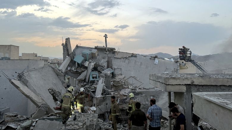 People and first-responders gather atop a building that was hit by an Israeli strike in Tehran on June 13, 2025. Israel hit about 100 targets in Iran on June 13, including nuclear facilities and military command centres and killing senior figures including the armed forces chief and top nuclear scientists. (Photo by MEGHDAD MADADI / TASNIM NEWS / AFP) (Photo by MEGHDAD MADADI/TASNIM NEWS/AFP via Getty Images)          