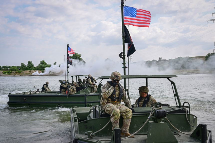 US soldiers operate pusher vessels, to be used to assemble and operate a transportation barge across Danube river, during a military exercise in Frecatei, eastern Romania, on June 13, 2025.