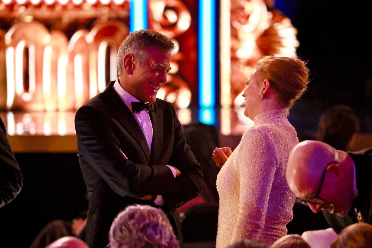 George Clooney and Sarah Snook talk in the audience.