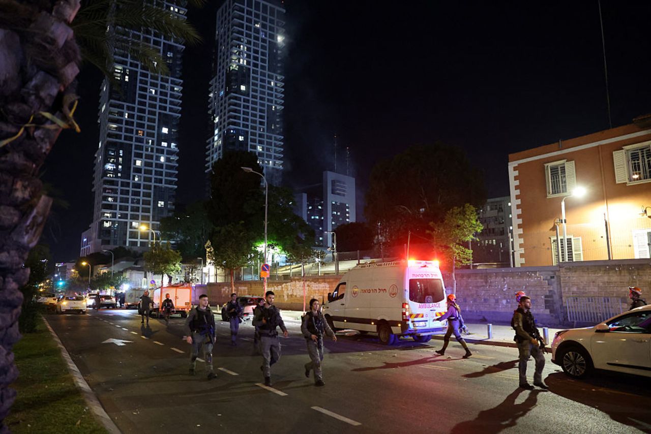 Tropas israelíes y socorristas se reúnen cerca de un edificio, aparentemente alcanzado por un misil disparado desde Irán, en el centro de Tel Aviv el 13 de junio de 2025.