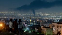 People gather on a hill to watch smoke rising in the distance from an Israeli airstrike in Tehran, Iran, on June 14, 2025. Iran's foreign minister said the country would respond "decisively and proportionally" to a wave of attacks that Israel launched beginning in the early hours of June 13. The attacks targeted multiple military, scientific and residential locations, as well as senior government officials.