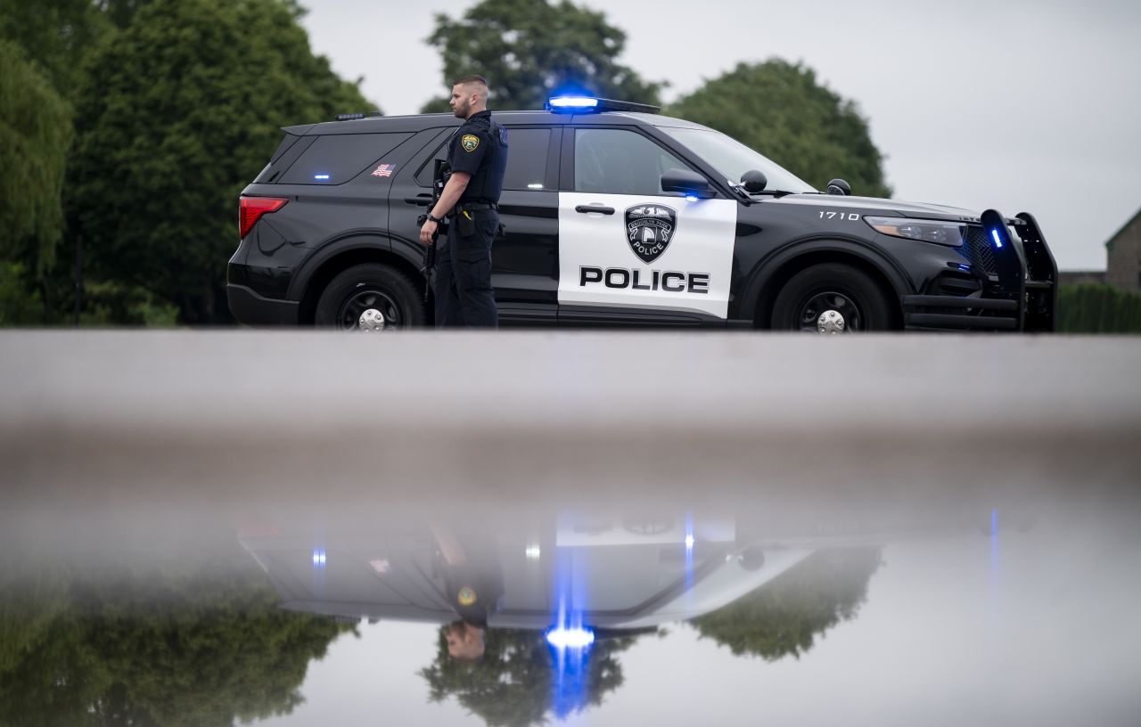 A Brooklyn Park police officer looks on as police guard the entrance to a neighborhood on Saturday.