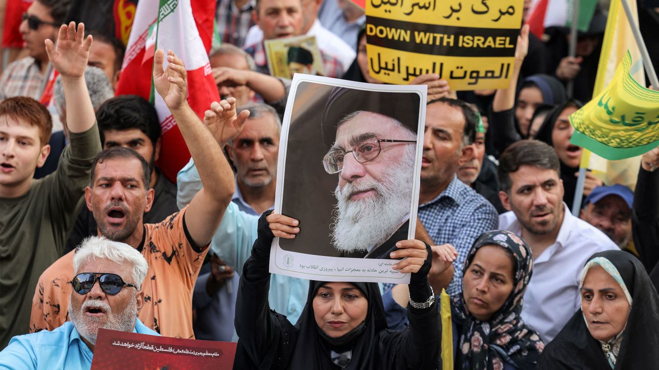 A demonstrator holds a picture of Iran's Supreme Leader Ayatollah Ali Khamenei while gathering with others during a rally in solidarity with the government against Israel's attacks on Iran and to mark Eid al-Ghadir, when according to Shiite Muslim belief the Islamic prophet Mohamed designated his nephew and companion Ali ibn Abi Talib as his successor, at Enghelab (Revolution) Square in Tehran on June 14, 2025. (Photo by Atta KENARE / AFP) (Photo by ATTA KENARE/AFP via Getty Images)          