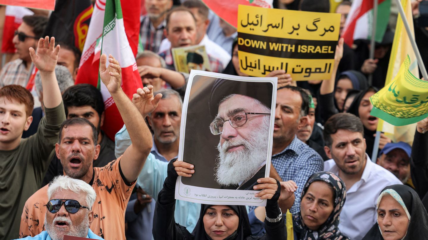 A demonstrator holds a picture of Iran's Supreme Leader Ayatollah Ali Khamenei while gathering with others during a rally in solidarity with the government against Israel's attacks on Iran and to mark Eid al-Ghadir, when according to Shiite Muslim belief the Islamic prophet Mohamed designated his nephew and companion Ali ibn Abi Talib as his successor, at Enghelab (Revolution) Square in Tehran on June 14, 2025. (Photo by Atta KENARE / AFP) (Photo by ATTA KENARE/AFP via Getty Images)          