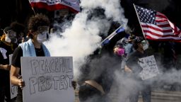 Un manifestante lanza una bomba de gas lacrimógeno a las fuerzas del orden durante los enfrentamientos durante la protesta "No Kings" en Los Ángeles el 14 de junio de 2025.