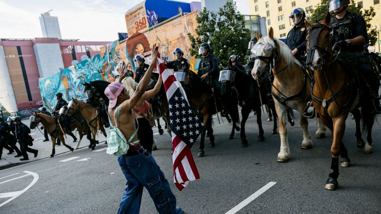Demonstrators react facing mounted LAPD officers during clashes following the "No Kings" national protest against the Trump administration, after an unlawful assembly was declared in Los Angeles on June 14, 2025. For hours, thousands of people in Los Angeles peacefully celebrated their defiance of US President Donald Trump Saturday with music, marching, bubbles and balloons -- then police unexpectedly moved in, and chaos and confusion broke out. (Photo by ETIENNE LAURENT / AFP) (Photo by ETIENNE LAURENT/AFP via Getty Images)          