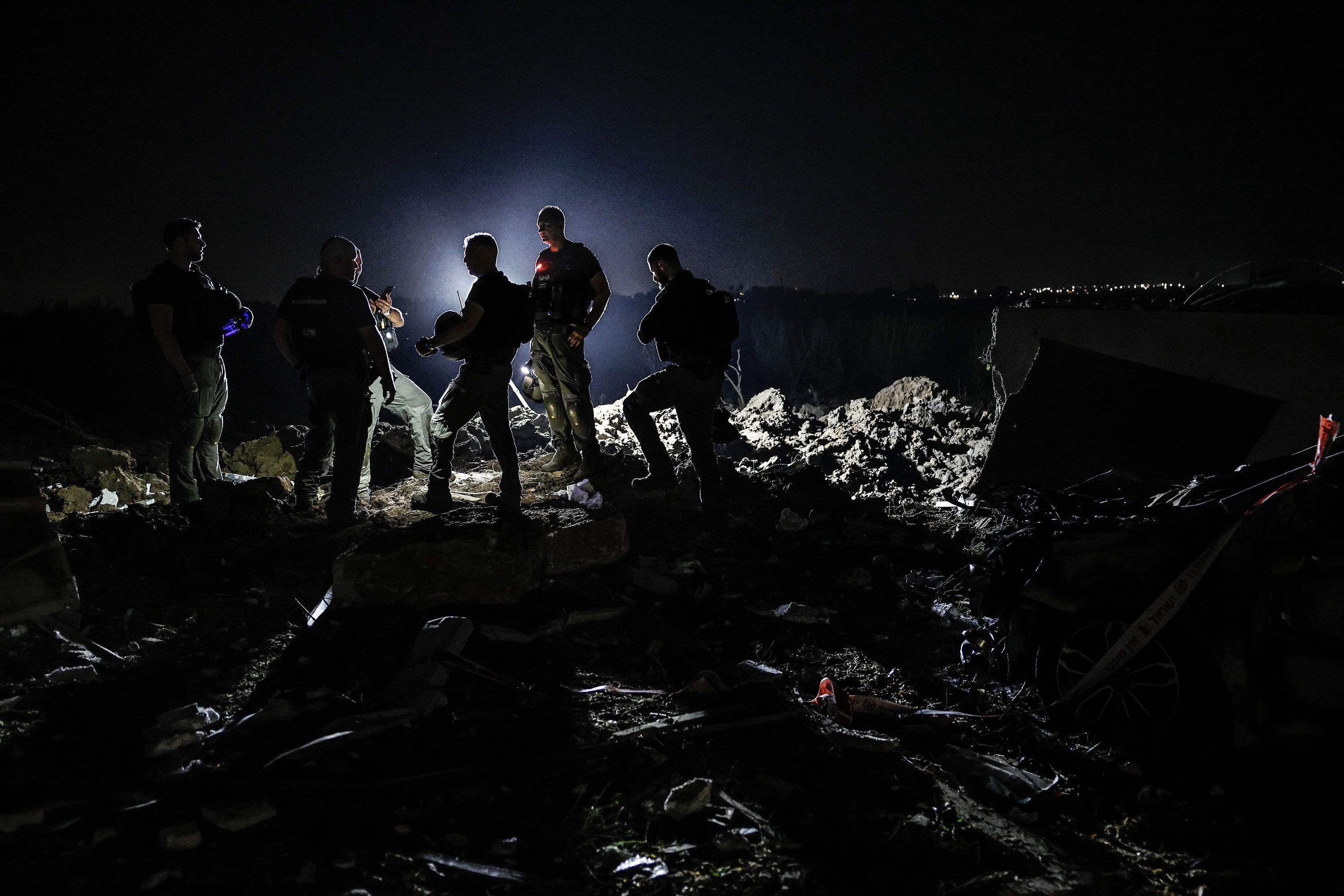 Israeli civil defense and emergency responders conduct nighttime search and rescue operations among damaged buildings after an Iranian missile strike in Qiryat Gat, Israel, on Sunday, June 15.