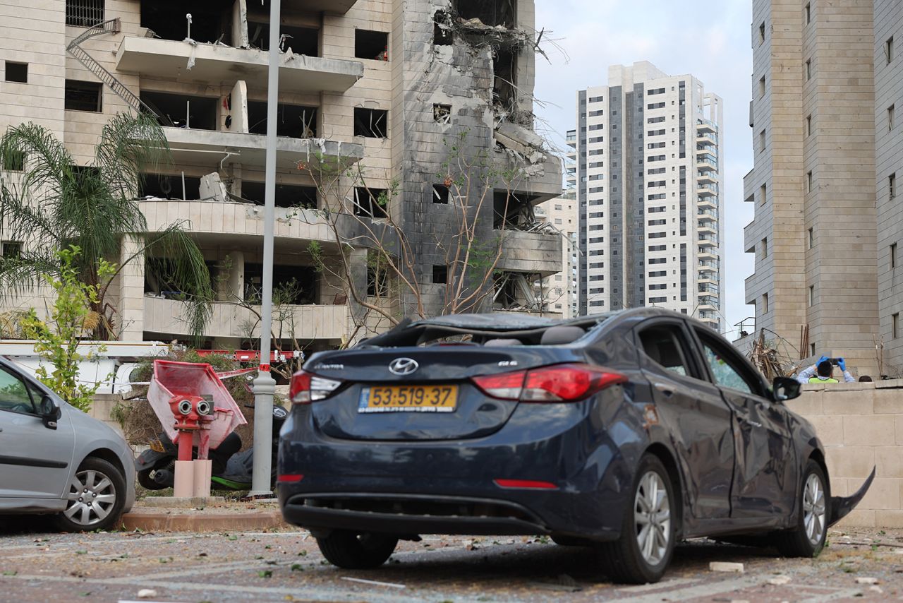 A damaged car is seen on the street in front of a damaged building in the Israeli city of Petah Tikva, east of Tel Aviv, on Monday.