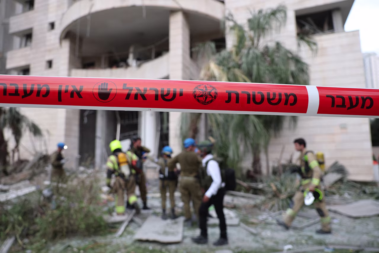 Responders inspect a damaged building following a strike by an Iranian missile in the Israeli city of Petah Tikva, east of Tel Aviv, on Monday.