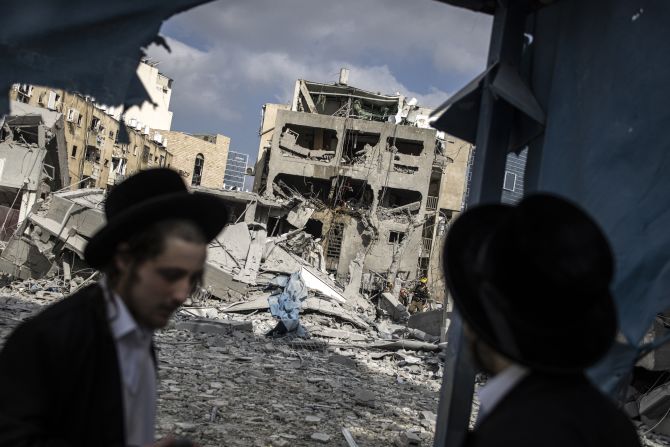 Men inspect damage at the site of an Iranian missile strike in Bnei Brak, Israel, on Monday, June 16.