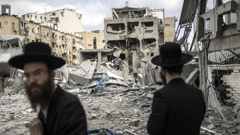 Ultra-Orthodox Jewish men inspect the damage at the site of an Iranian missile strike in Bnei Brak, east of Tel Aviv, on June 16, 2025. Iran unleashed a barrage of missile strikes on Israeli cities early on June 16, after Israel struck military targets deep inside Iran, with both sides threatening further devastation. (Photo by JOHN WESSELS / AFP) (Photo by JOHN WESSELS/AFP via Getty Images)          
