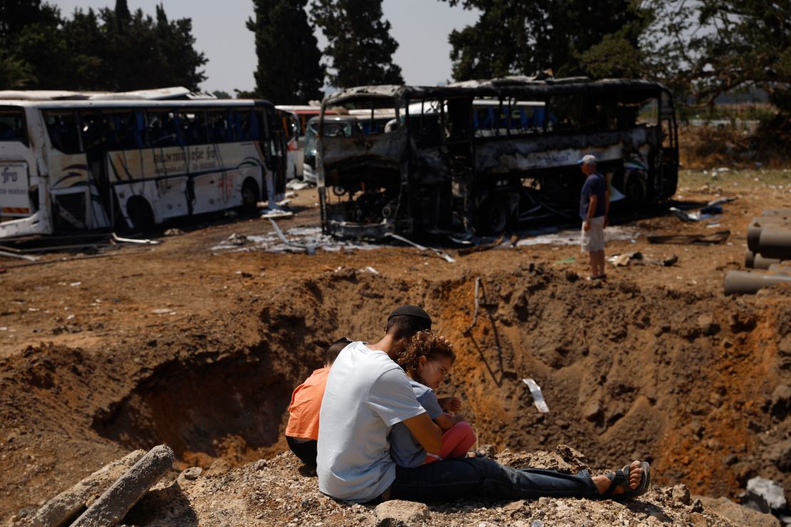 People are looking at the craters on the ground after a missile strike in Herzliya, Israel on June 17, 2025.