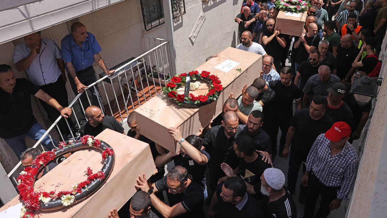 Mourners carry the caskets of victims of an Iranian missile attack which destroyed a three-storey building in the northern Arab-Israeli city of Tamra on the weekend killing four women, during a funeral in Tamra on June 17, 2025. An Iranian missile killed four people in the city of Tamra on June 14: Manar al-Qassem Abu al-Hija Khatib (39), her two daughters Hala (13) and Shada (20), and their relative Manar Diab Khatib (41). Dozens more were wounded.