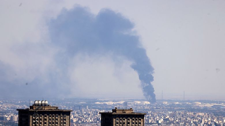 TOPSHOT - Smoke billows in the distance from an oil refinery following an Israeli strike on the Iranian capital Tehran on June 17, 2025. Israel and Iran exchanged fire again, the fifth day of strikes in their most intense confrontation in history, fuelling fears of a drawn-out conflict that could engulf the Middle East. (Photo by ATTA KENARE / AFP) (Photo by ATTA KENARE/AFP via Getty Images)          