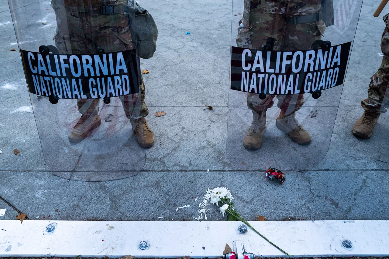  A flower is placed in front of members of the National Guard as they confront protesters in downtown Los Angeles on Friday.