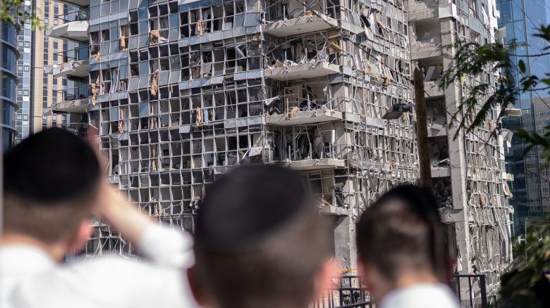 19 June 2025, Israel, Ramat Gan: Israelis stand in front of a building damaged by an Iranian missile on Ramat-Gan. Photo: Ilia Yefimovich/dpa (Photo by Ilia Yefimovich/picture alliance via Getty Images)