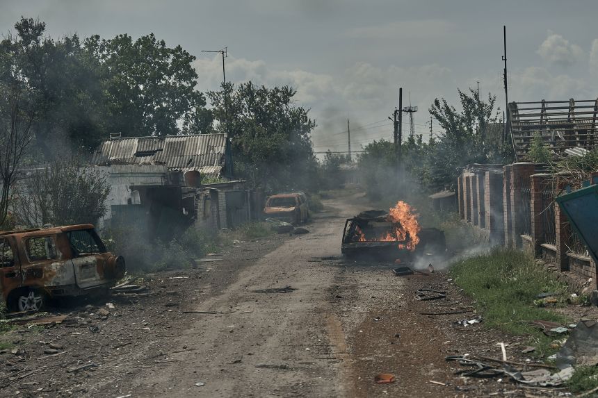 Burnt cars lie in the street as civilians are evacuated from Pokrovsk, Ukraine, by police on June 19.