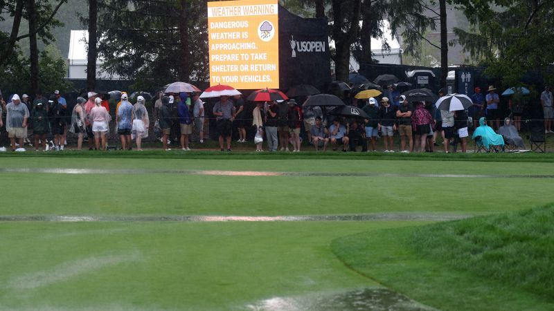 Heavy rains suspend play at US Open, raising the possibility of a Monday finish to the final round