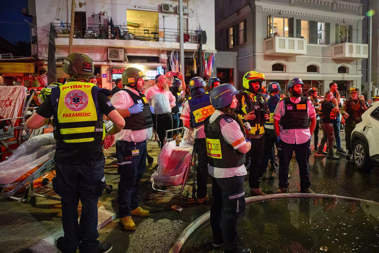Israeli rescue workers and security personnel inspect and clear the buildings and area hit by an Iranian rocket in Central Tel Aviv, Israel on Monday.