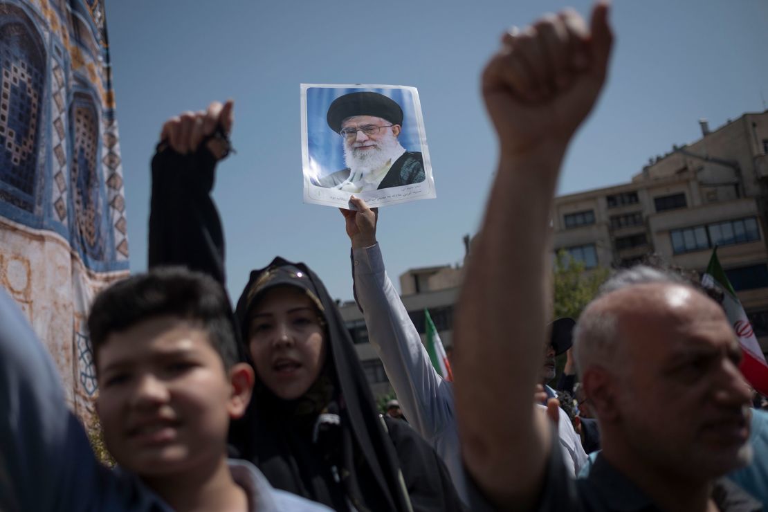 Iranian worshippers shout anti-US and anti-Israel slogans while one of them holds up a portrait of Iran's Supreme Leader Ayatollah Ali Khamenei during a rally to condemn Israeli attacks on Iran, in Tehran on Friday.