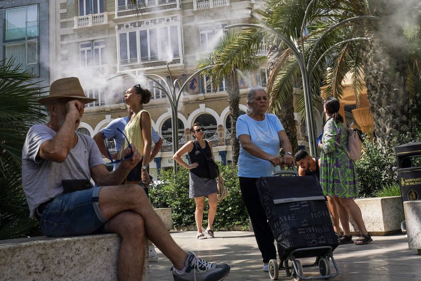 People take advantage of water mist fountains in Valencia, Spain on June 21, 2025, as parts of the country experience a heatwave.