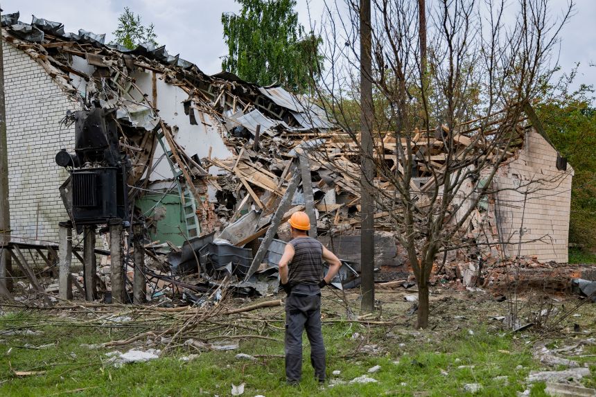 A worker with the Chernihiv electricity distribution and supply company responds to a damaged power line, near a building destroyed by Russian missile in Chernihiv, Ukraine, on June 17.