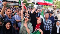 Iranians lift flags and chant during a rally protesting the US attack on Iran in Enghelab Square in Tehran on June 22, 2025. Iran's President Masoud Pezeshkian condemned US strikes on nuclear sites on June 22, saying in his first response that the attack revealed Washington was "behind" Israel's military campaign in the Islamic republic.