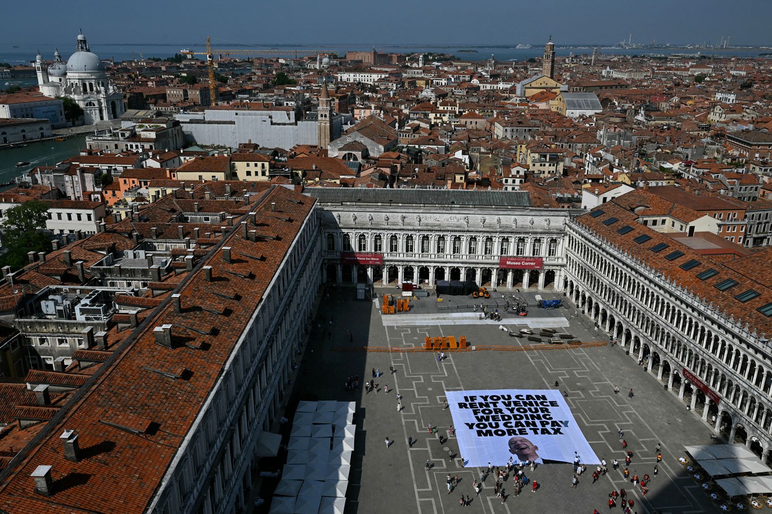 Activists of the international environmental group Greenpeace deploy a giant banner at St. Mark Square in Venice on Monday, June 23. It reads, "If you can rent Venice for your wedding you can pay more tax."