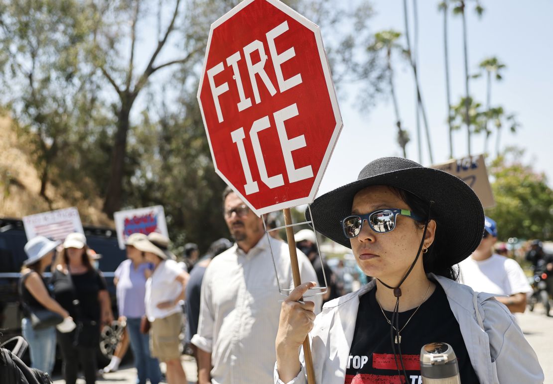 Protesters demonstrate not far from federal agents staged outside a gate of Dodger Stadium on June 19 in Los Angeles.