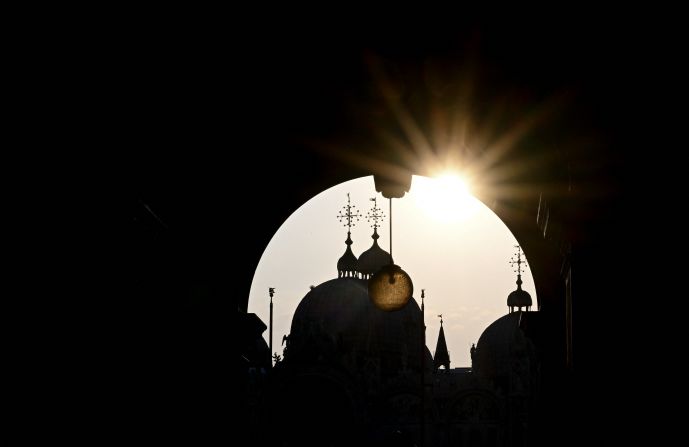 The domes of Venice's St. Mark's Basilica are silhouetted in the early morning on Wednesday.