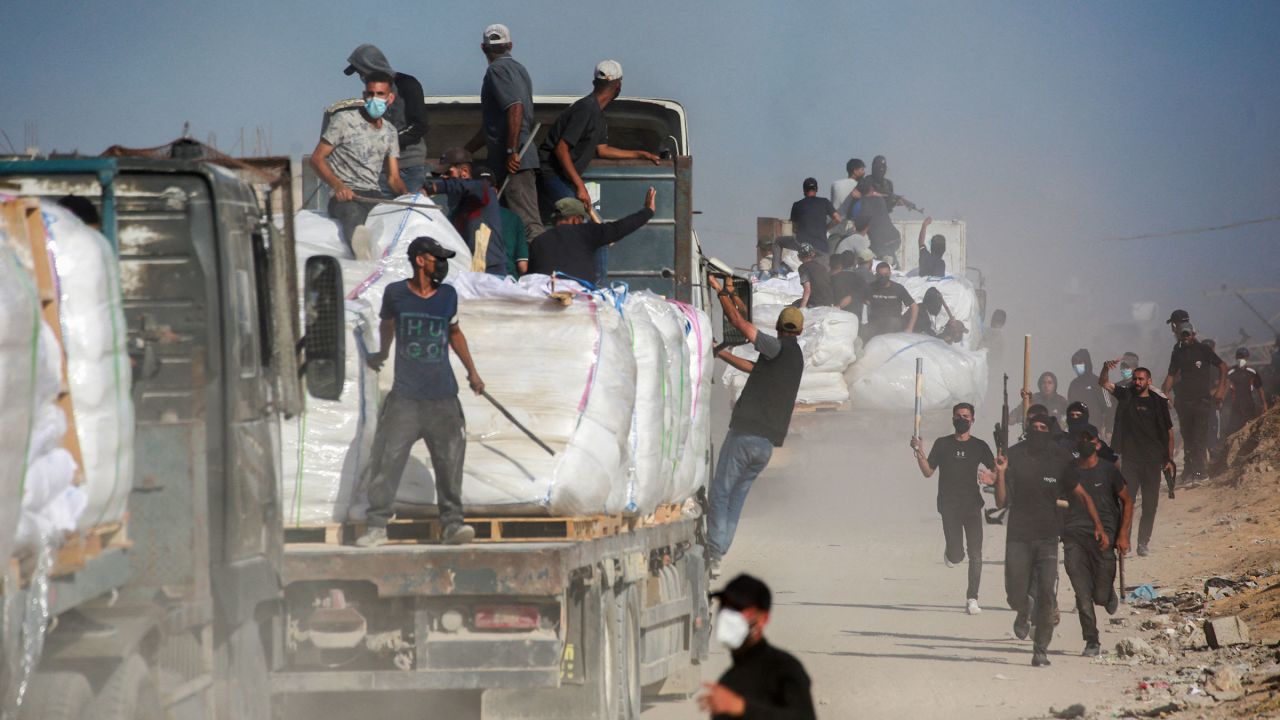 Members of Palestinian families who have organized to prevent theft guard trucks carrying aid which entered the Gaza Strip from the Israeli-controlled Zikim crossing on June 25.