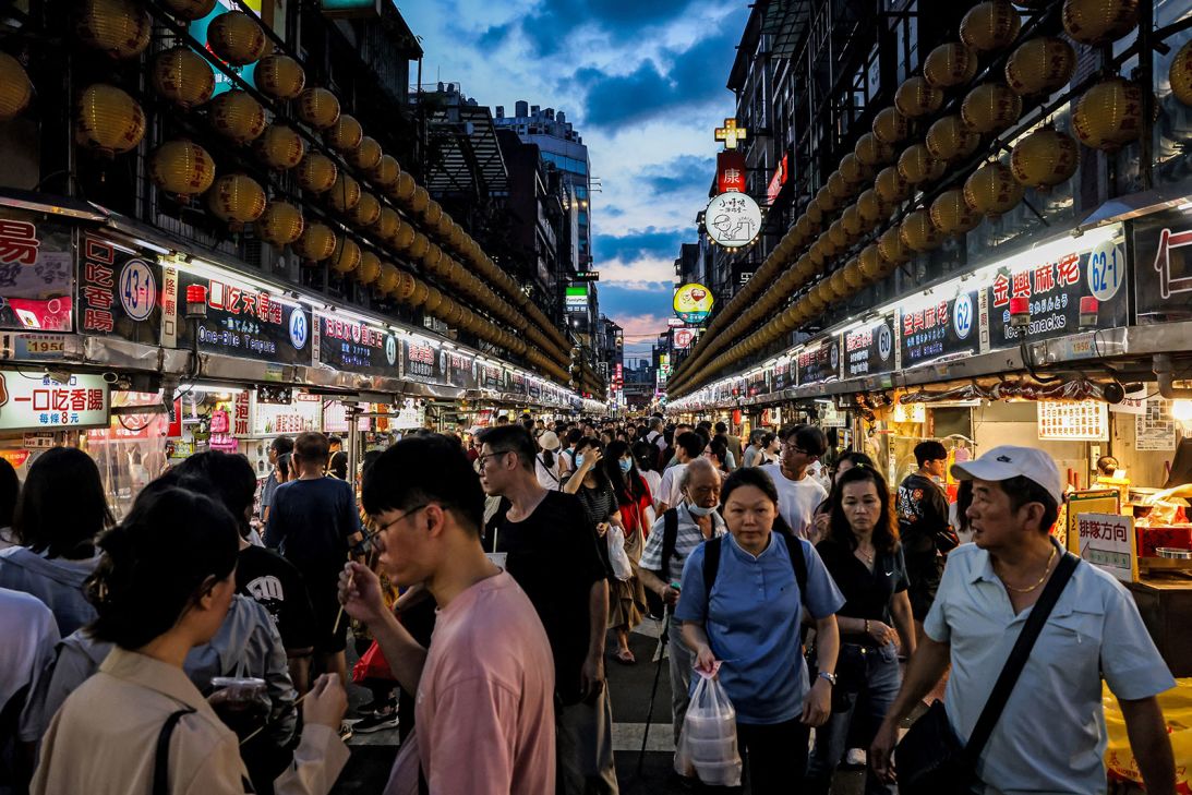 Visitors walk around a local night market in Keelung on June 26, 2025.
