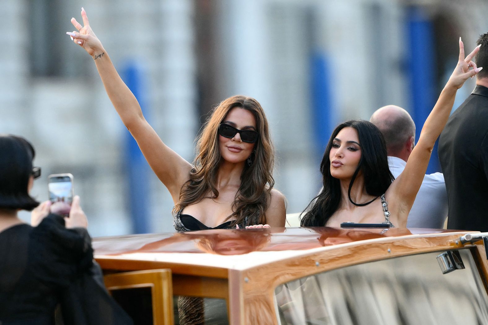 Kris Jenner takes a photo of Khloe and Kim Kardashian on a taxi boat on Thursday.