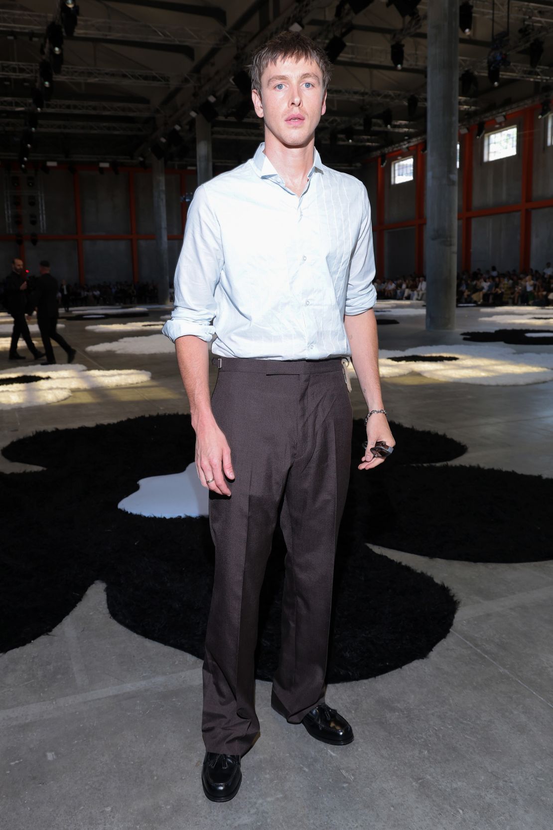 While Harris Dickinson opted for a casual button down to watch the Prada Spring-Summer 2026 runway.