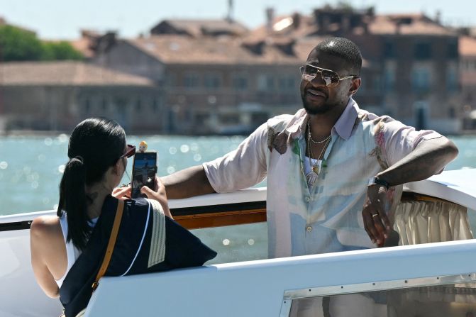 Jennifer Goicoechea takes a photo of her husband, Usher, while they ride a boat taxi in Venice on Friday.