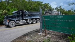 Trucks leave the Dade-Collier Transition and Training Airport as demonstrators protest the construction of an immigrant detention center, dubbed "Alligator Alcatraz," in the Everglades near Ochopee, Florida, on June 28, 2025. Florida began construction this week on a detention center surrounded by fierce reptiles and cypress swamps, an "Alligator Alcatraz" in the Everglades wetlands, as part of US President Donald Trump's expansion of deportations of undocumented migrants. The chosen site, an abandoned airfield in the heart of a sprawling network of mangrove forests, imposing marshes and "rivers of grass" that form the conservation area, will house large tents and beds for 1,000 "criminal aliens," according to state Attorney General James Uthmeier. (Photo by GIORGIO VIERA / AFP) (Photo by GIORGIO VIERA/AFP via Getty Images)          