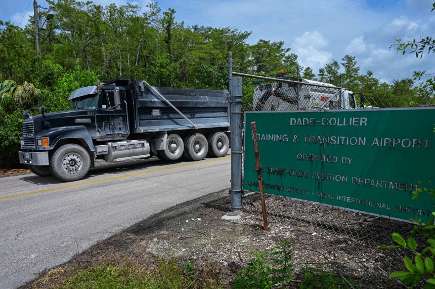 Trucks leave the Dade-Collier Transition and Training Airport as demonstrators protest the construction of an immigrant detention center on June 28.