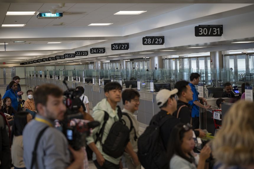 Travelers at Dulles International Airport in Virginia are pictured during a media event related to incoming foreign nationals on June 29, 2025.