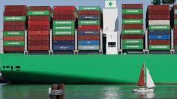 A sailboat passes shipping containers stacked on a container ship at the Port of Los Angeles on June 25 in Los Angeles, California. Many economists say the damage from the trade war could still be on the way.