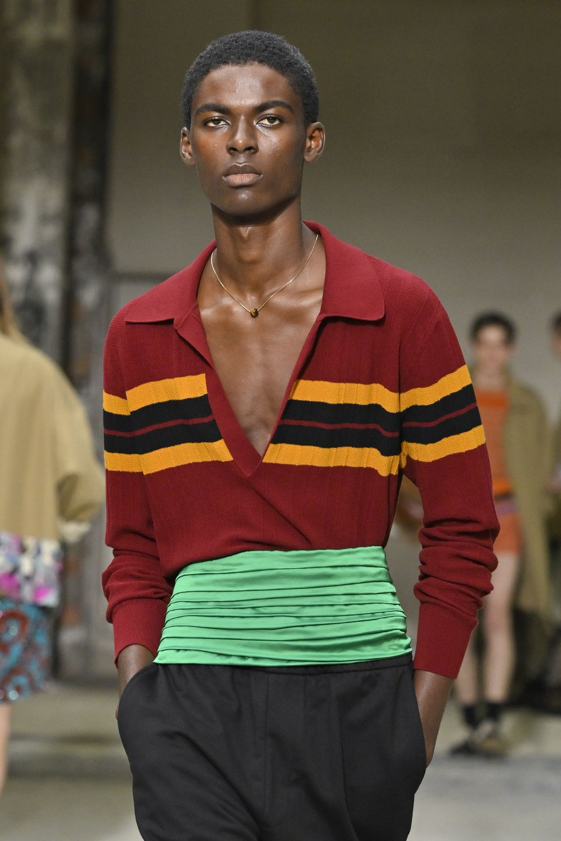 Une bande de Cumber bijou au-dessus d'un polo à faible coupe de Dries Van Noten.
